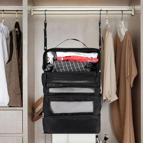 Black hanging suitcase shelves hung from a closet rail between clothes, with folded clothes on the top shelf
