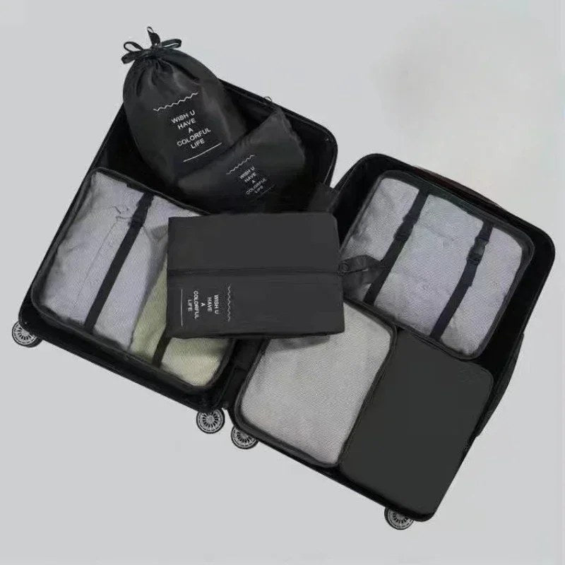 Black packing cubes laid out in an open suitcase