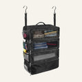 Hanging suitcase shelves in black with clothes on three mesh shelves