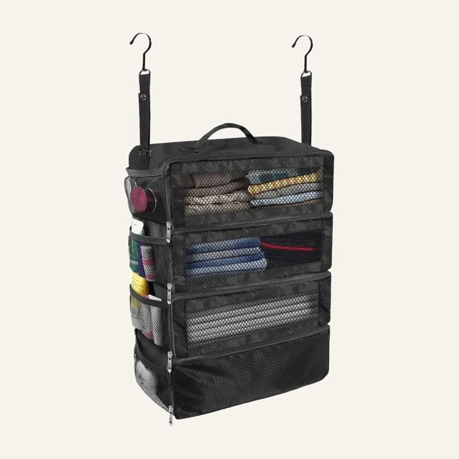 Hanging suitcase shelves in black with clothes on three mesh shelves