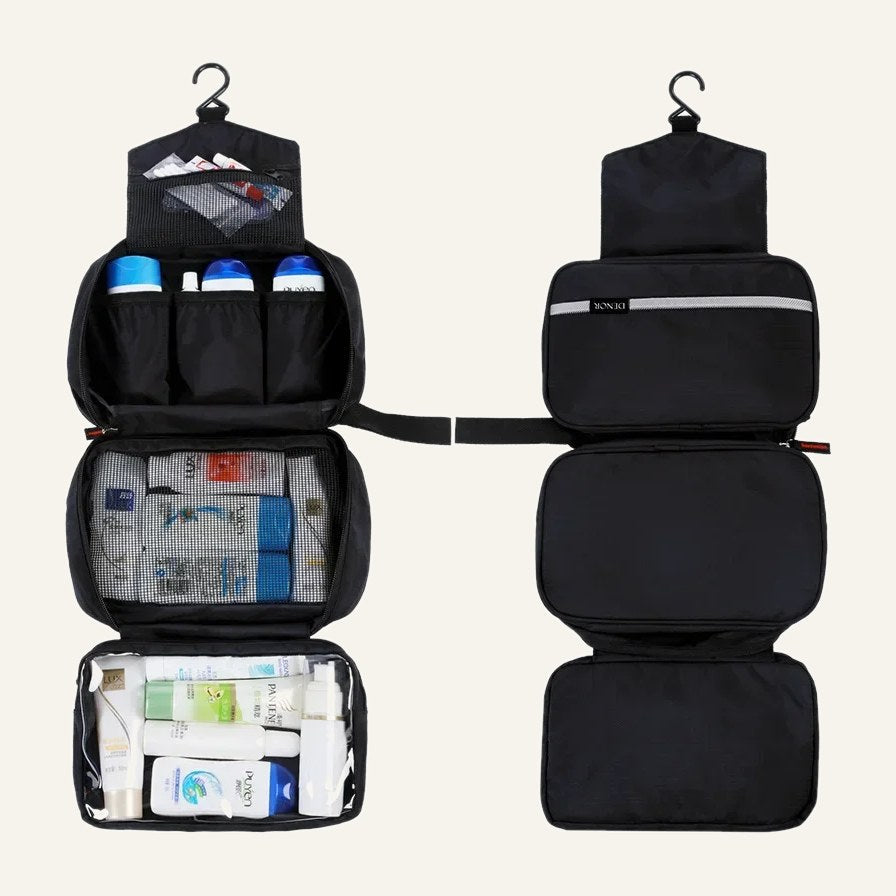 The black toiletry bag hanging open with pockets filled, next to it folded closed